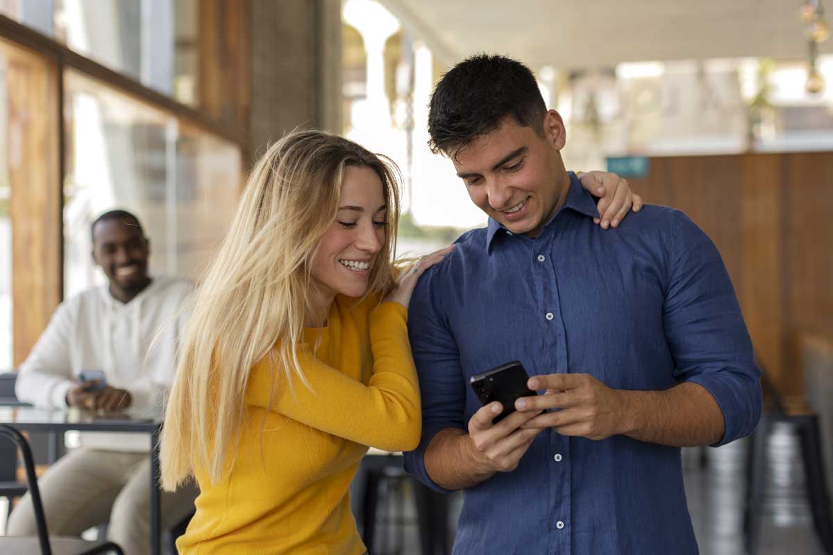Um casal proprietario de assistência técnica para celular feliz por ter mais clientes para assistência técnica de celular. Créditos da imagem: freepik.com