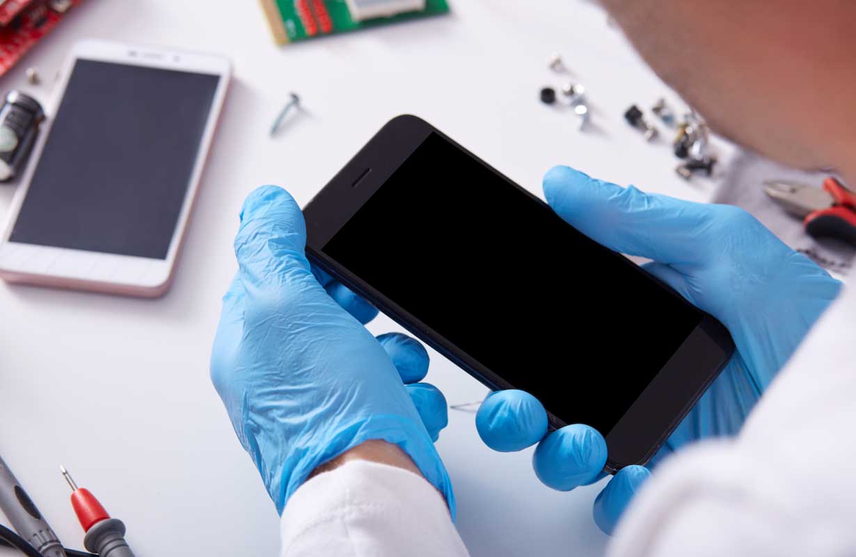 Técnico analisa celulares sem conserto na assistência técnica. Créditos da imagem: freepik.com Técnico analisa celulares sem conserto na assistência técnica. Créditos da imagem: freepik.com