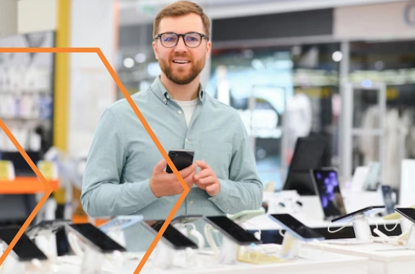 Um técnico sorri enquanto segura o celular de um cliente.